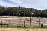 A circular dirt track surrounded by bushland.