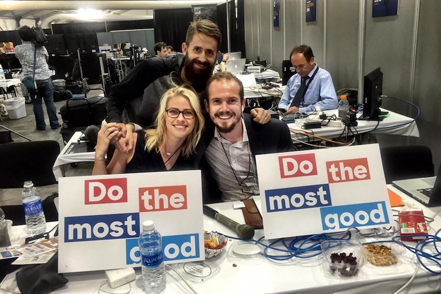 Whalan, March and Fulton in media centre at Democrat National Convention sitting in front of signs saying do the most good.