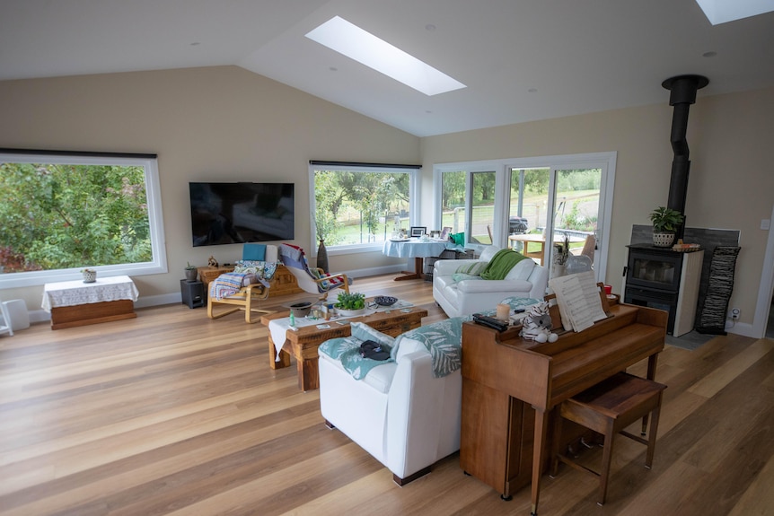 A lounge room with furniture and polished floorboards