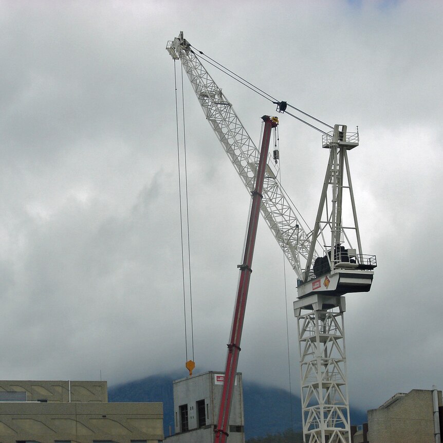 Two cranes work on a city building in Hobart