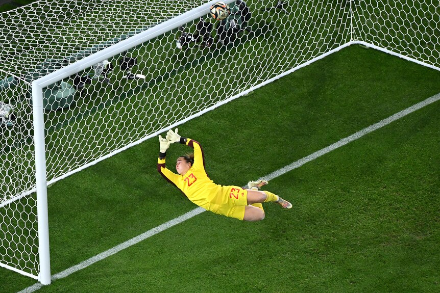 Spain goalkeeper Cata Coll dives as a ball hits the crossbar in the Women's World Cup final.