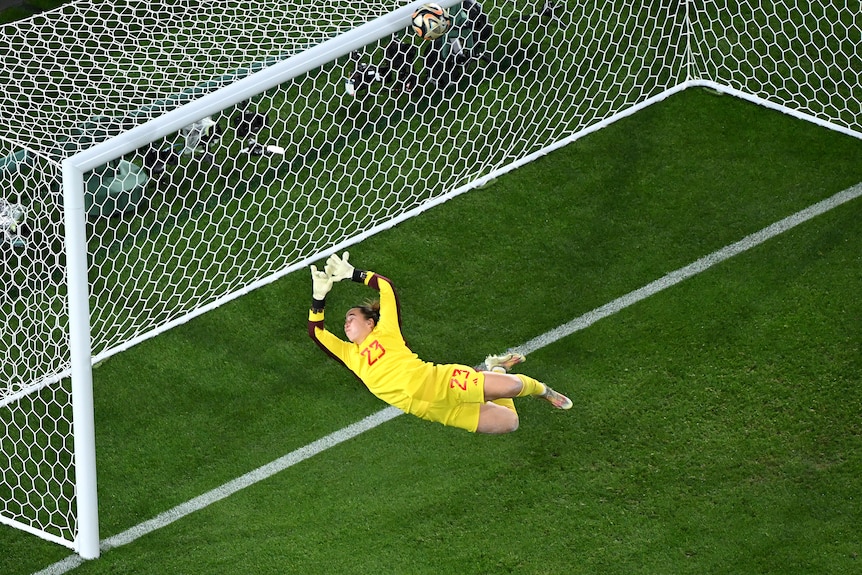 Spain goalkeeper Cata Coll dives as a ball hits the crossbar in the Women's World Cup final.