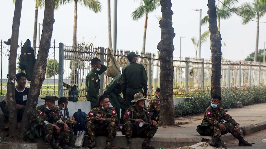 Soldiers sit on the street in Yangon