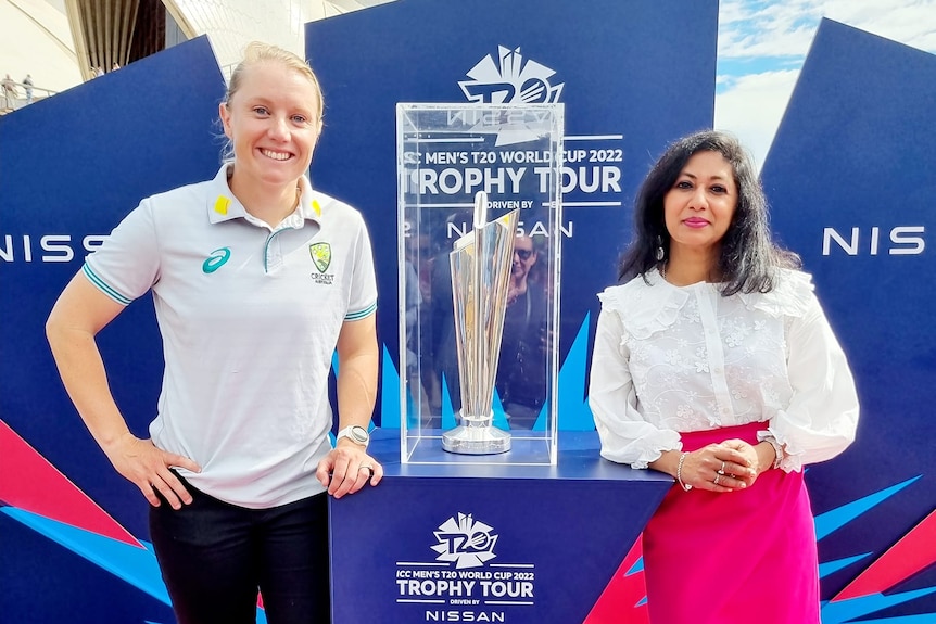 Molina Asthana stands next to a trophy in a cabinet with the Sydney Opera House in the background.