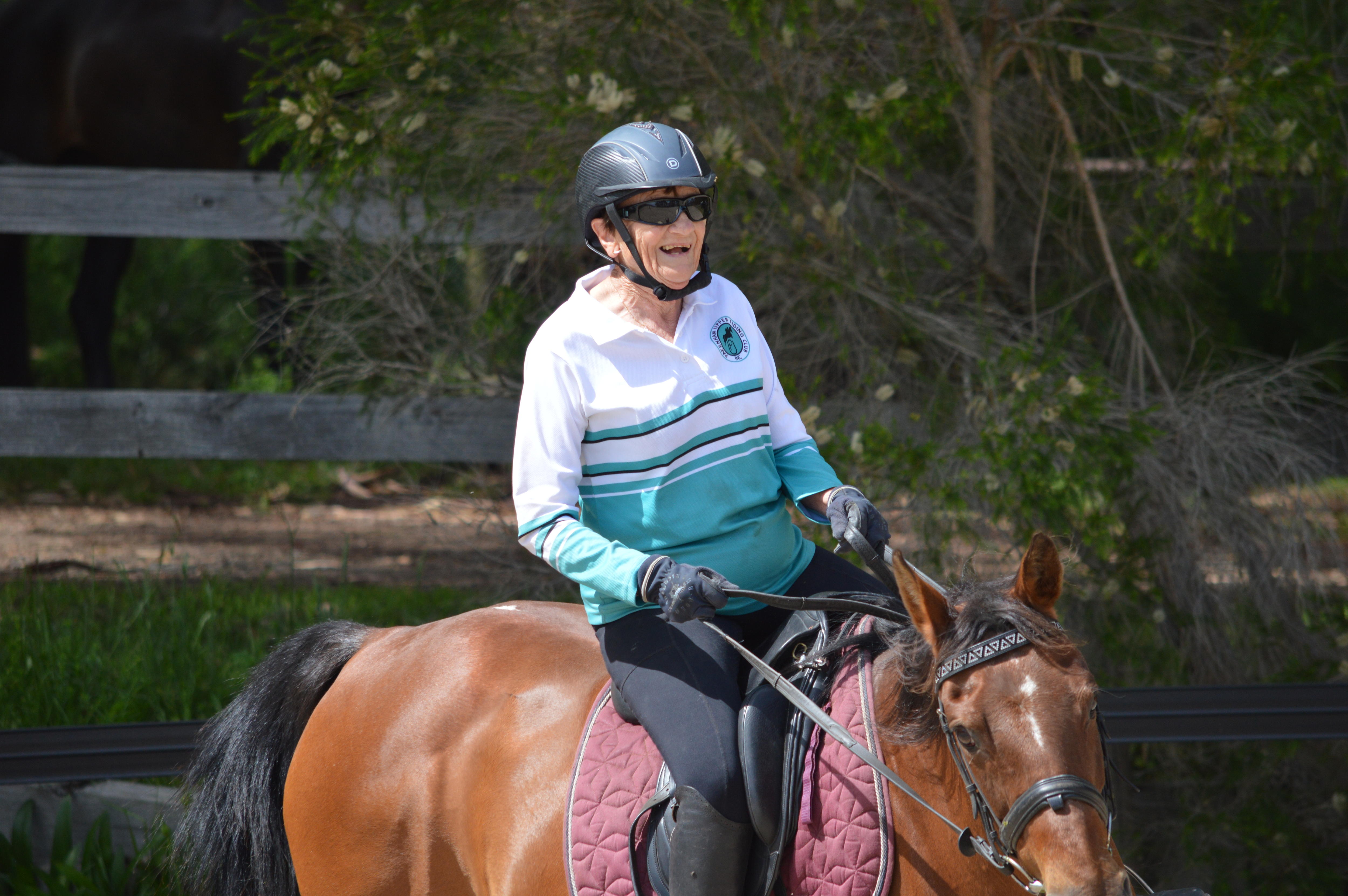 Joan Jeffery aparece sorrindo amplamente enquanto andava a cavalo