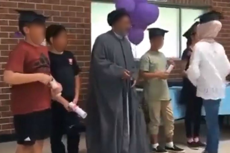 kids wearing graduation caps and holding diplomas - their faces are blurred