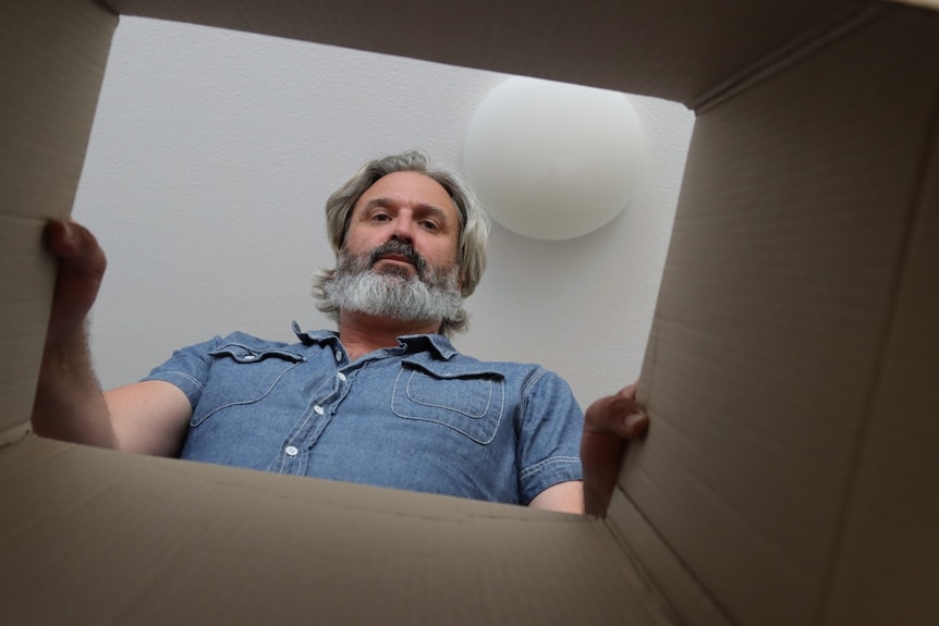 A man looking through a box