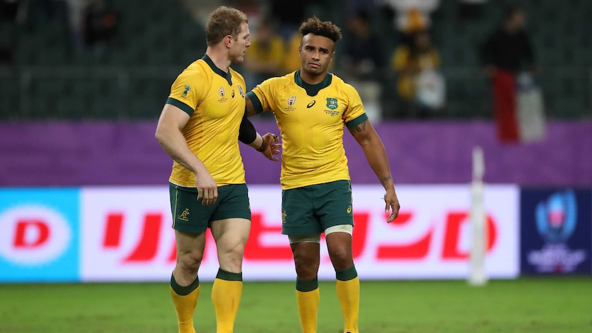 Two Walabies players leave the field with their arms around each other after losing to England at the Rugby World Cup.