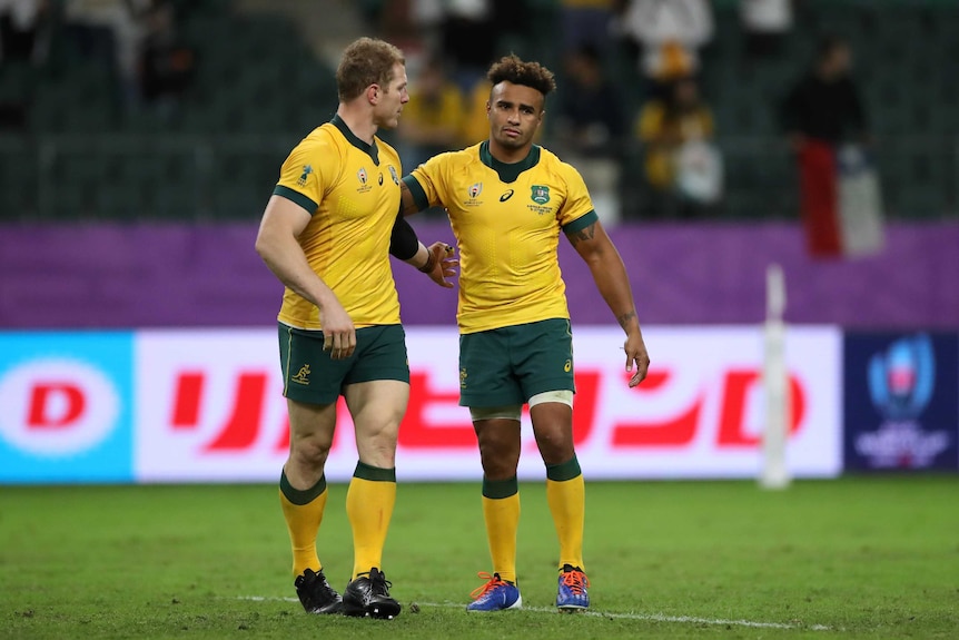 Two Walabies players leave the field with their arms around each other after losing to England at the Rugby World Cup.