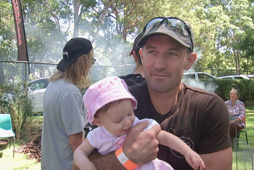 Man holding a baby at a local show at Mount Tamborine.