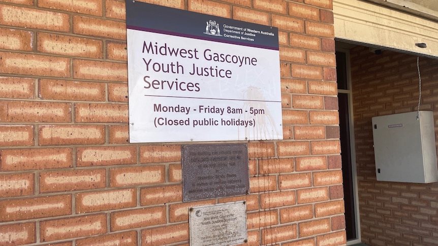 Sign on brick wall reads Midwest Gascoyne Youth Justice Services and opening hours
