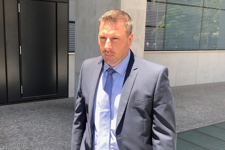 James Colin Burnham walks outside the Supreme Court in Brisbane wearing a suit on November 26, 2019