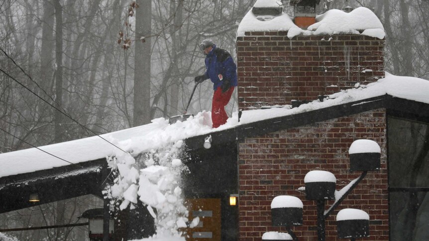 Man shovels snow of his roof