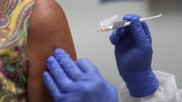 A woman gets jabbed by a needle