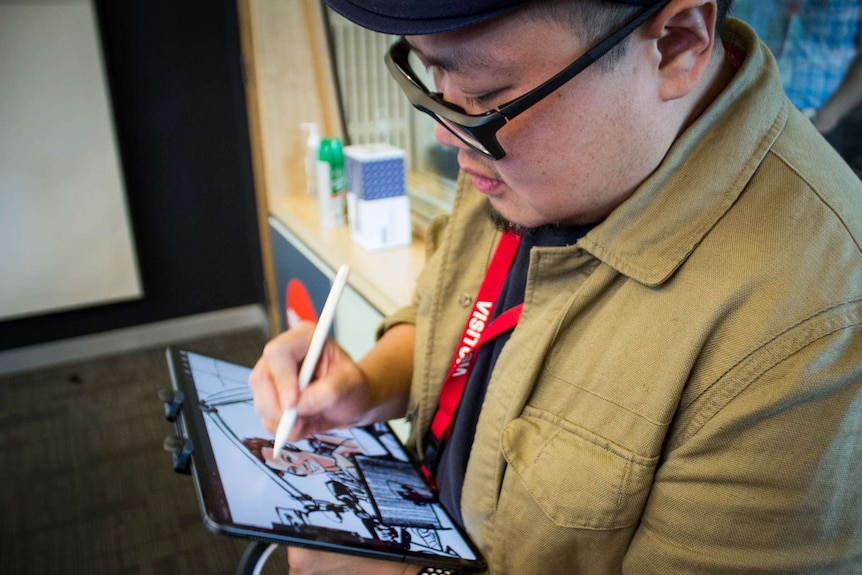 Man sketching on an tablet.