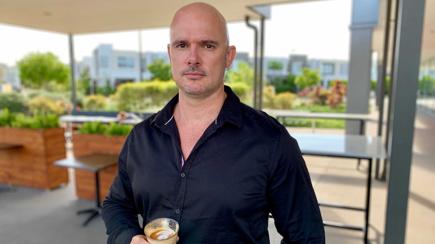 Brent Harrison, a former Jamaica Blue franchisee, holds a coffee.