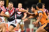 James Tedesco uses his left hand to fend off the attempted tackles of Alex Glenn and Anthony Milford.