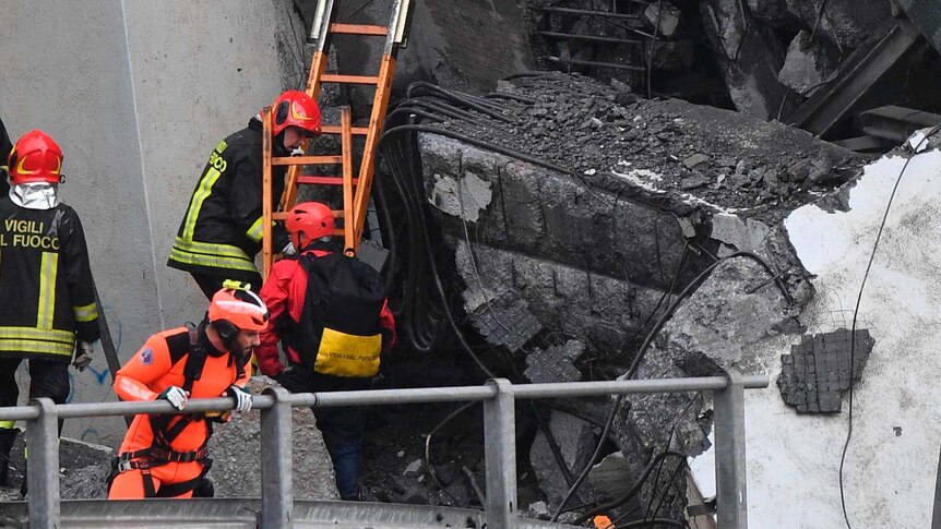 Rescuers work among the debris of the collapsed Morandi highway bridge in Genoa.