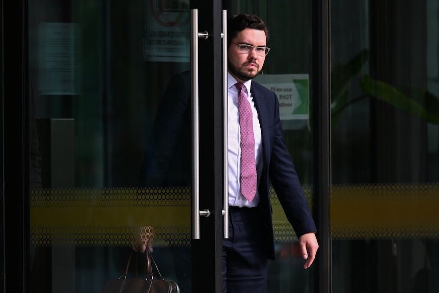 A man walking through a glass door. 