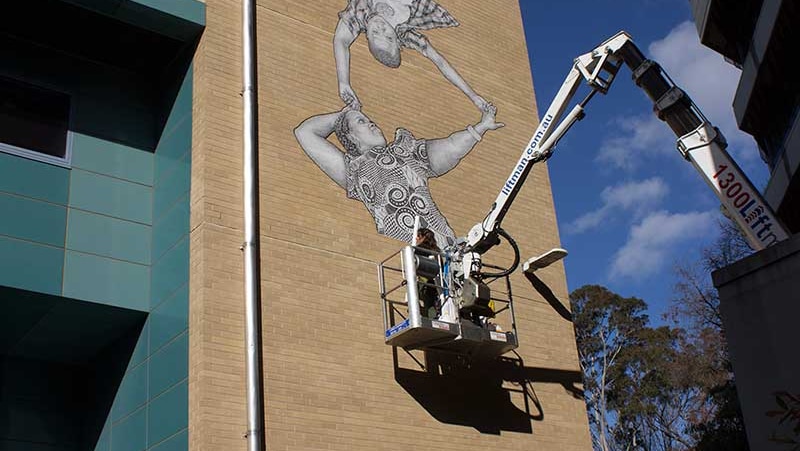 Baby Guerrilla at work on a mural at Victoria University