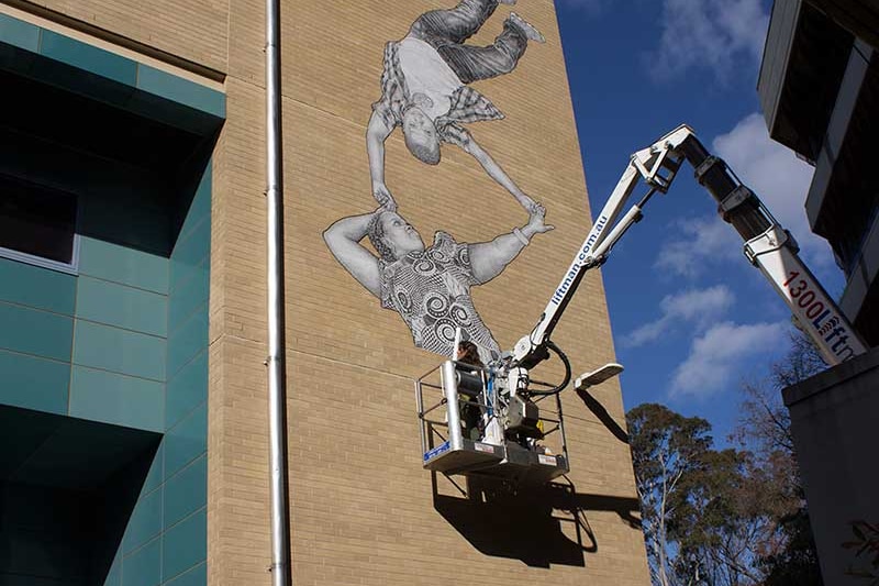 Baby Guerrilla at work on a mural at Victoria University