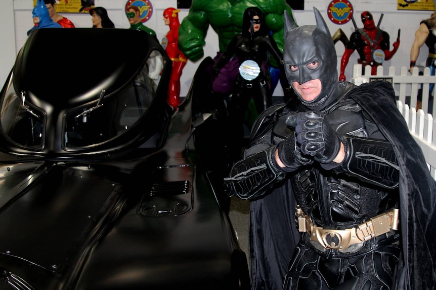 Batman enthusiast and impersonator Rino D'Alfonso with his replica of the batmobile.