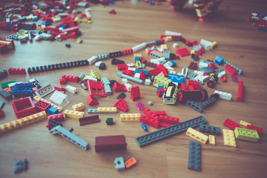 Lego scattered on a wooden floor
