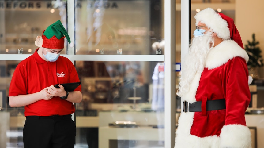A man dressed as Santa wearing a face mask.