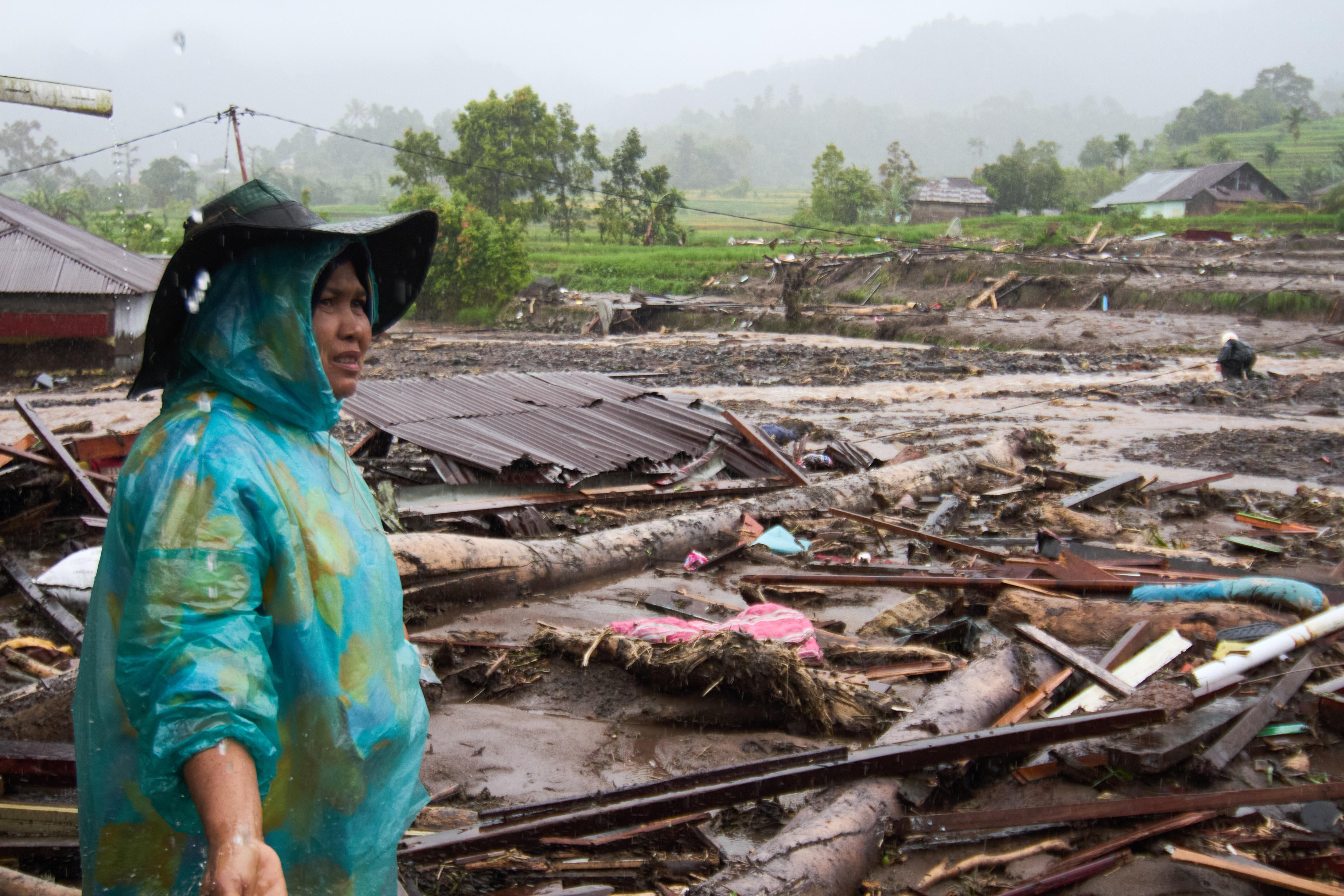 Mujer y destrucción de casas, madera, escombros. 