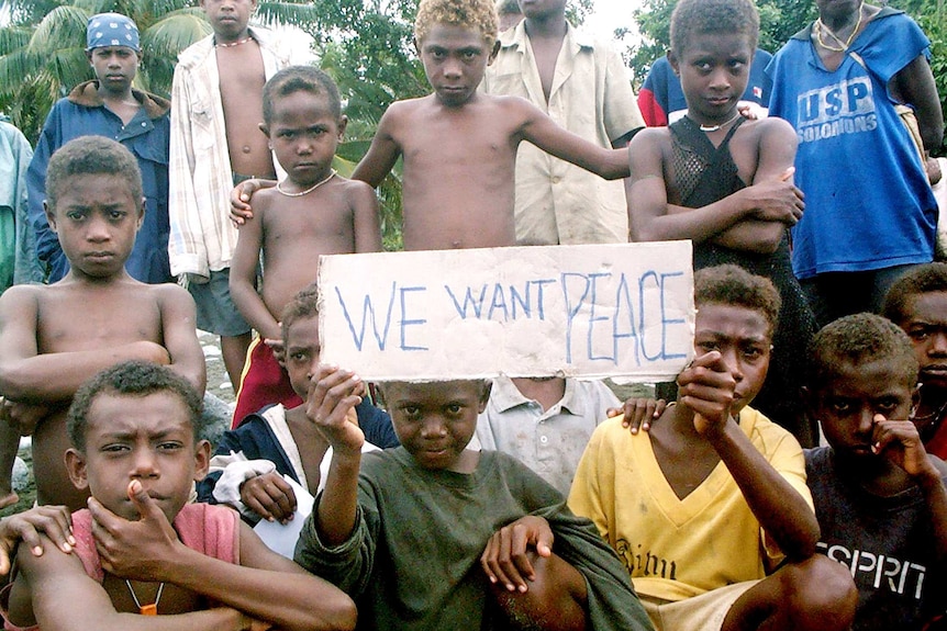 Children hold a sign asking for peace in the rebel stronghold of the Weathercoast, Solomon Islands, July 2003.