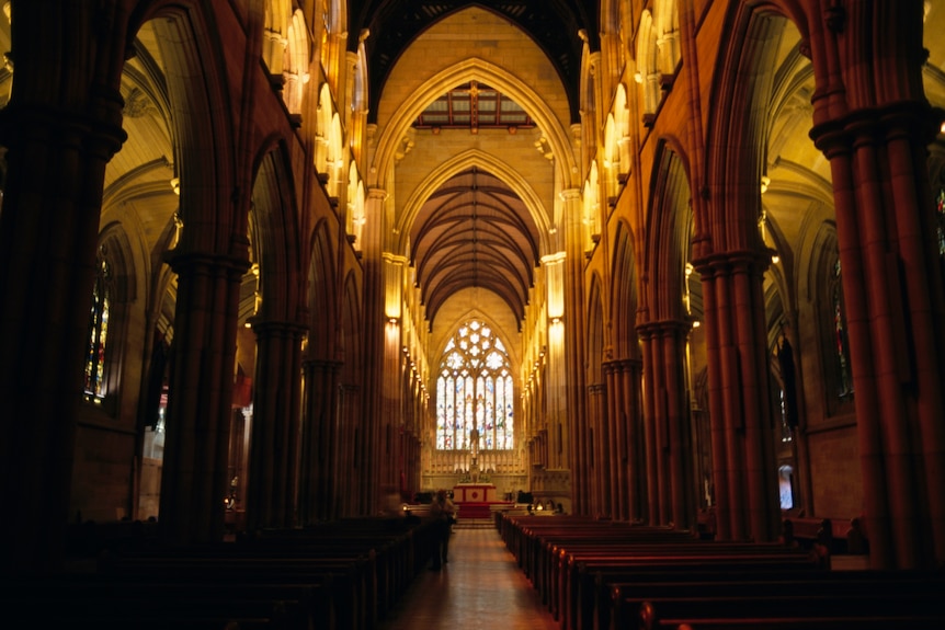 The interior of a grand cathedral, with light coming in from the main window.