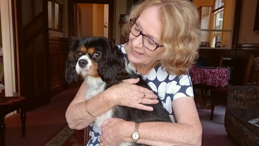 Woman hugs pet dog.