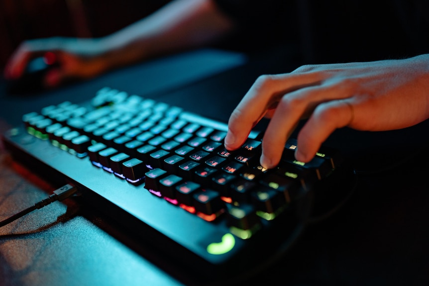 Hands using a computer mouse and keyboard