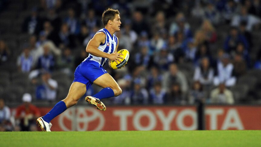 Andrew Swallow runs with the ball for the Kangaroos against Gold Coast at Docklands in April 2012.
