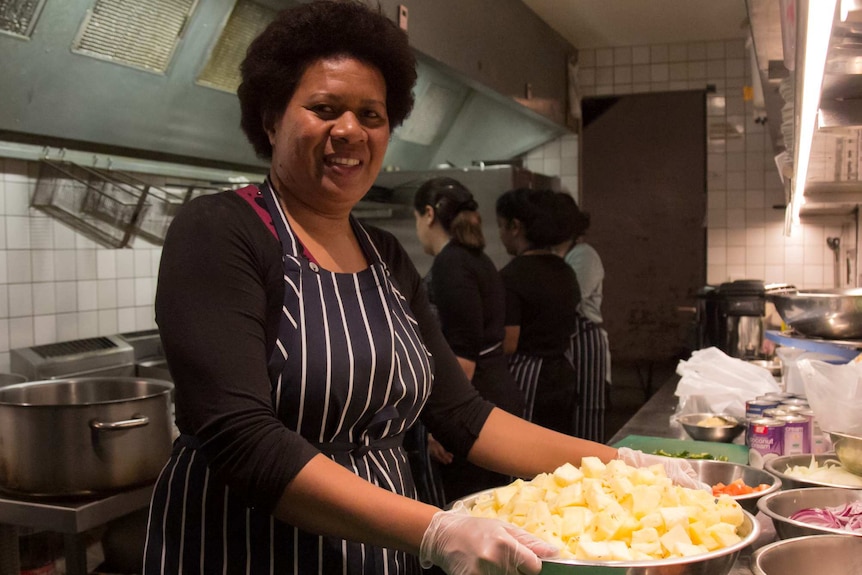 Sue Naga prepares food in the kitchen