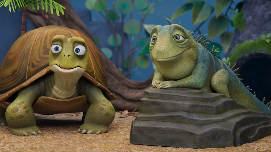 Animated still shows a smiling lizard on a rock next to a wide-eyed turtle, inside a terrarium.