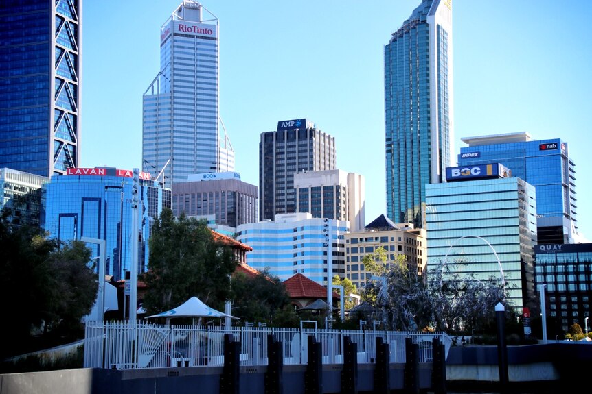 Skyscrapers in the Perth CBD, with a white fence in the foreground.