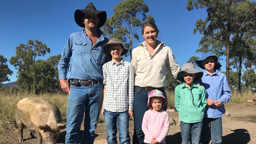 The Murnane family standing together on their pig farm.