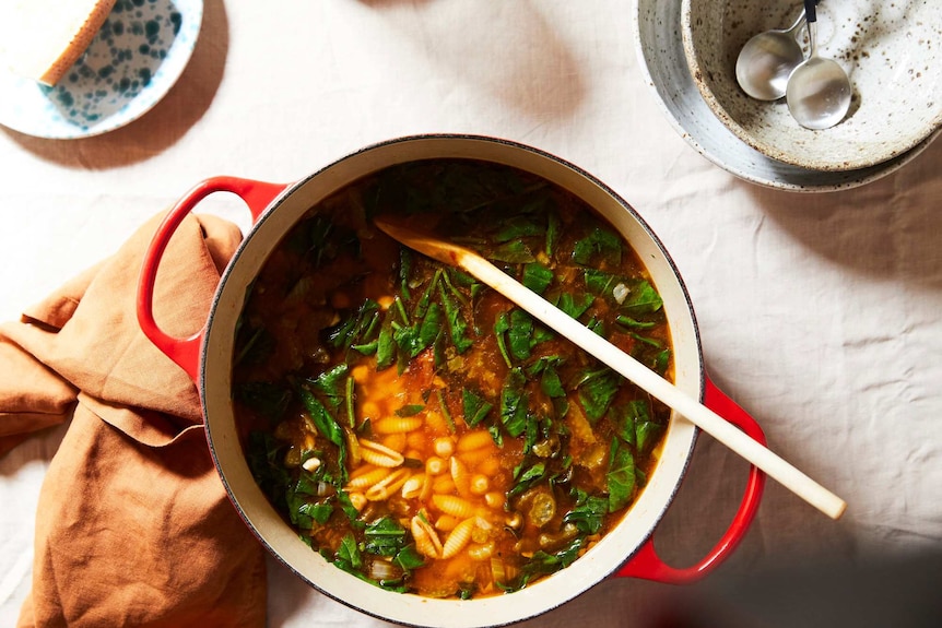 A pot of pasta soup with spinach and chickpeas, an easy dinner recipe made with pantry staples for the cooler months.