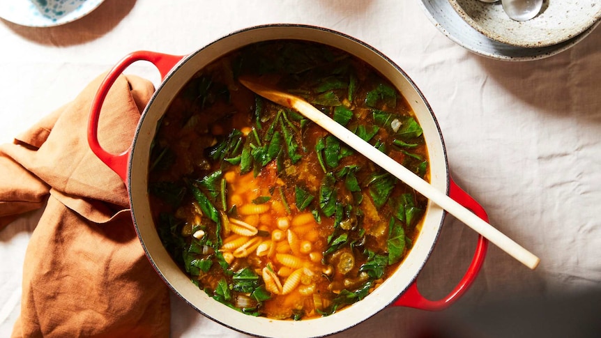 A pot of pasta soup with spinach and chickpeas, an easy dinner made with pantry staples for the cooler months.
