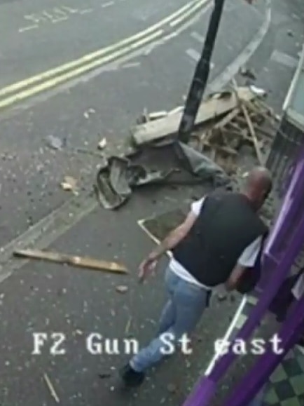 A man walks into a bar past debris from a bus accident.