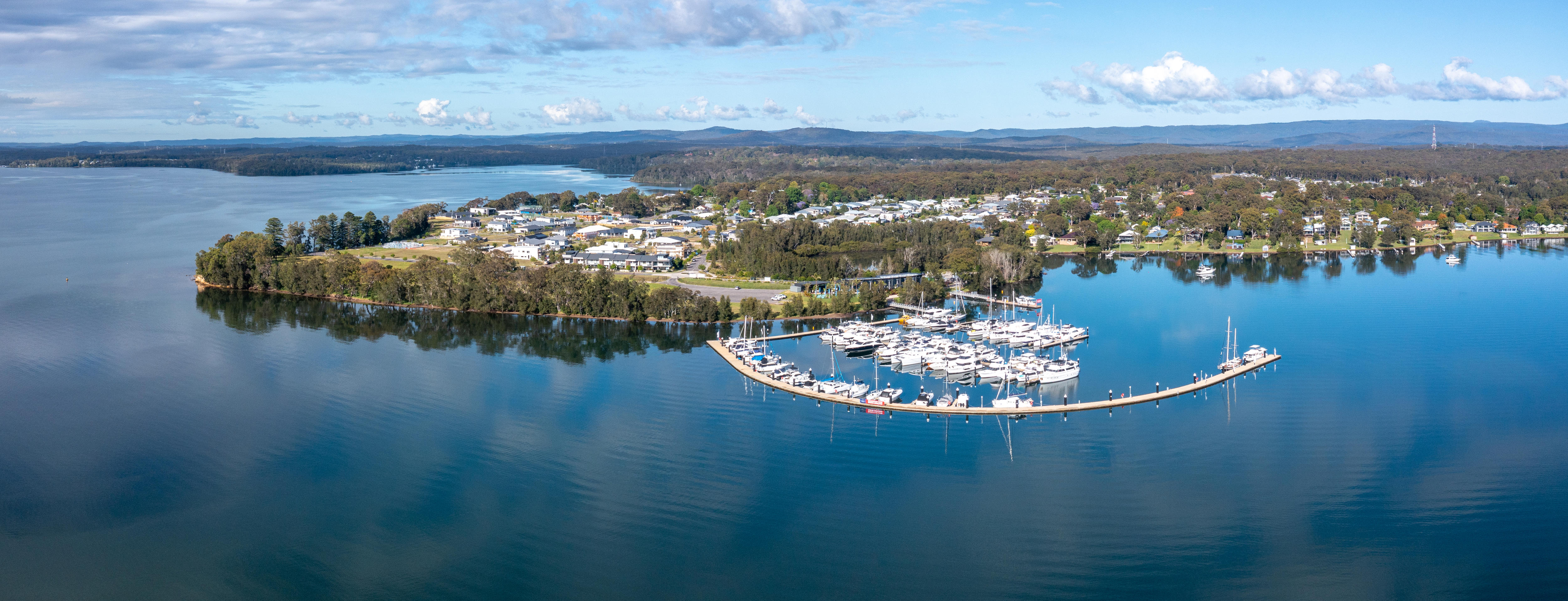 Aerial view of boats stored on a harbour with a city as a backdrop.