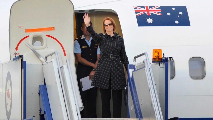 Prime Minister Julia Gillard boards a plane at Fairbairn Airport.