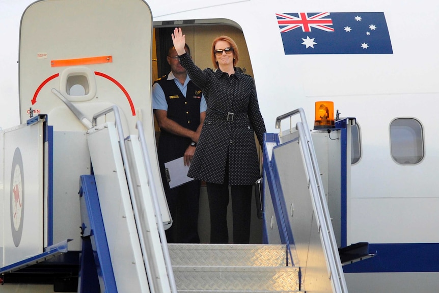 Prime Minister Julia Gillard boards a plane at Fairbairn Airport in Canberra.