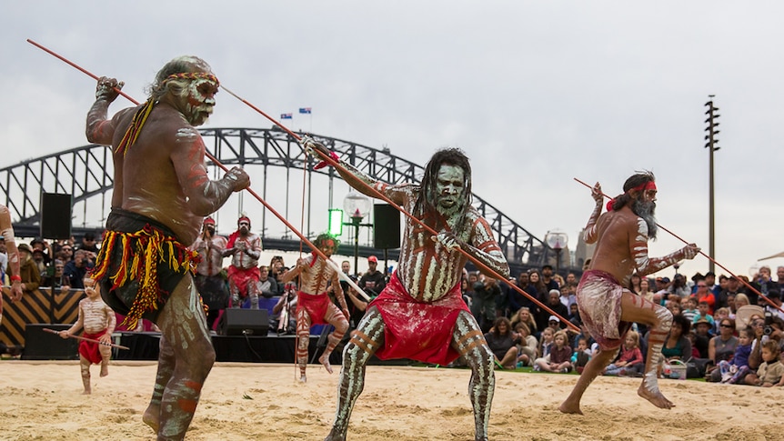 Aboriginal dancers lunging forward with spears.