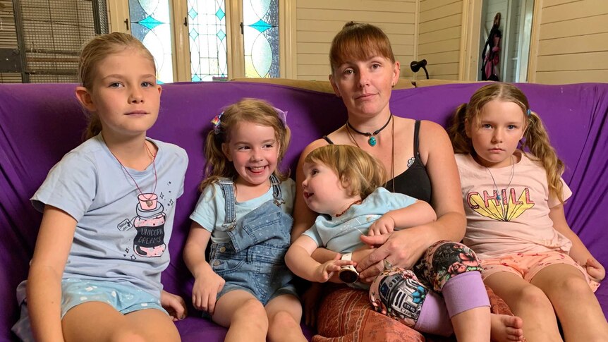 Kerryn Griffis and her children Maia, Brenna, Misty and Amber sitting on a purple sofa in their lounge room