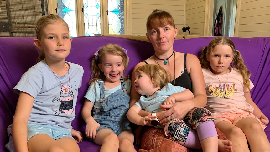 Kerryn Griffis and her children Maia, Brenna, Misty and Amber sitting on a purple sofa in their lounge room