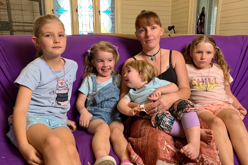 Kerryn Griffis and her children Maia, Brenna, Misty and Amber sitting on a purple sofa in their lounge room