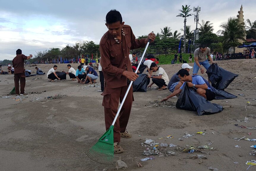 Kuta hotel workers clean up a Bali beach
