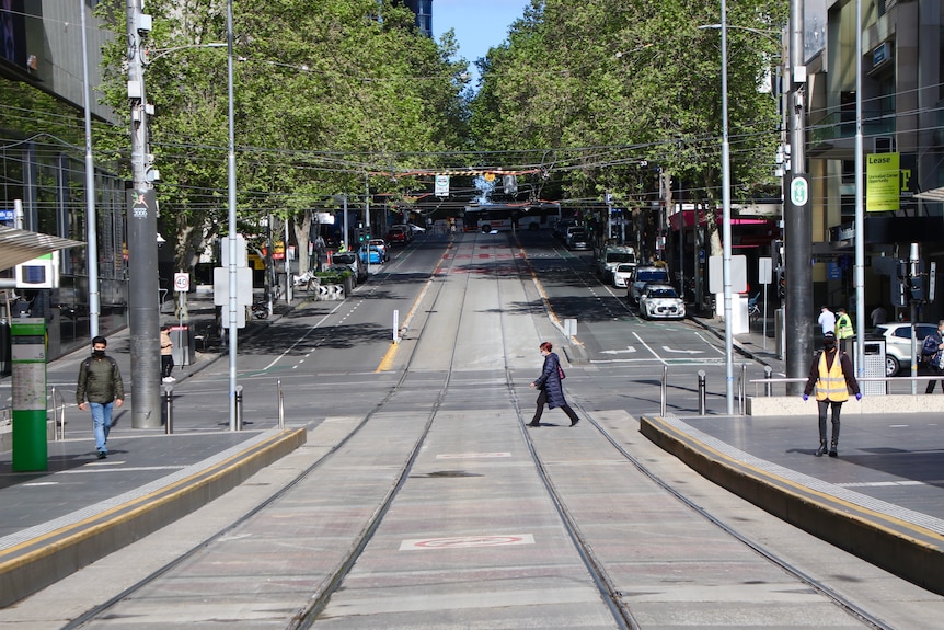 A woman crosses the street in Melbourne's CBD.